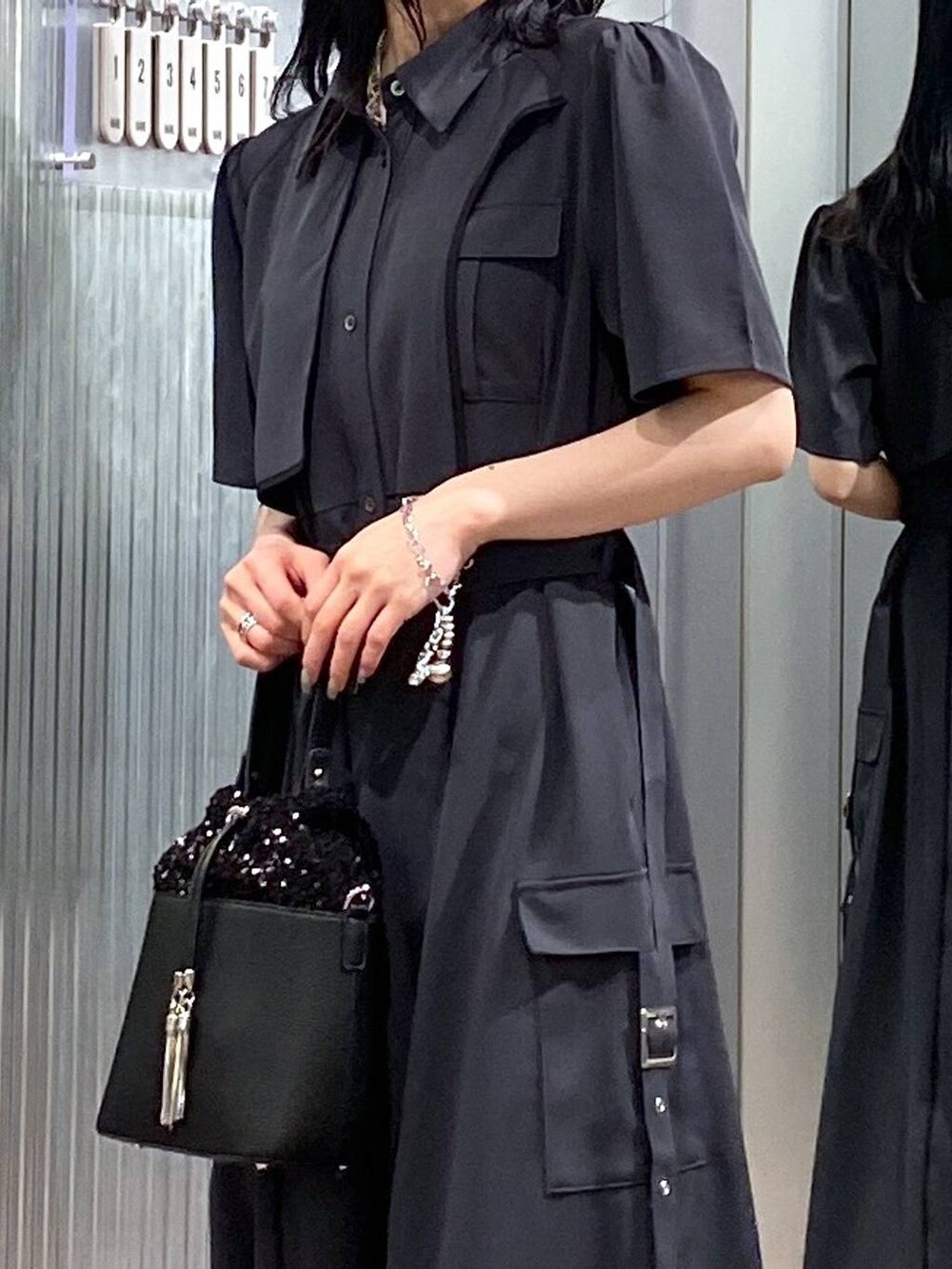 ブラック系のサンダル、グレー系のワンピース、ブラック系のショルダーバッグを着用したレディースの夏コーディネートの7枚目の写真