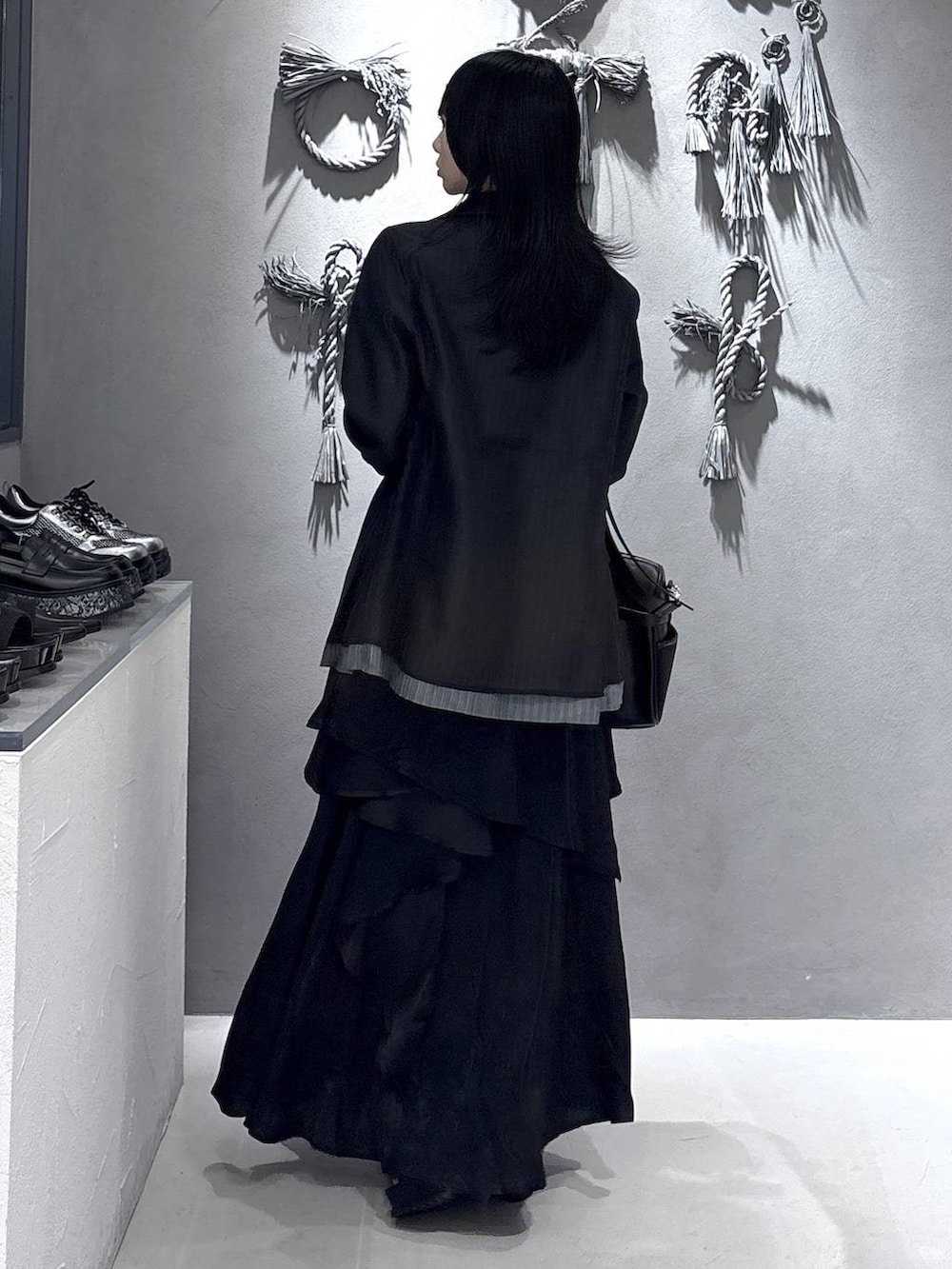 ブラック系のネクタイ、ブラック系のブーツ、パープル系のタンクトップを着用したレディースの春コーディネートの2枚目の写真