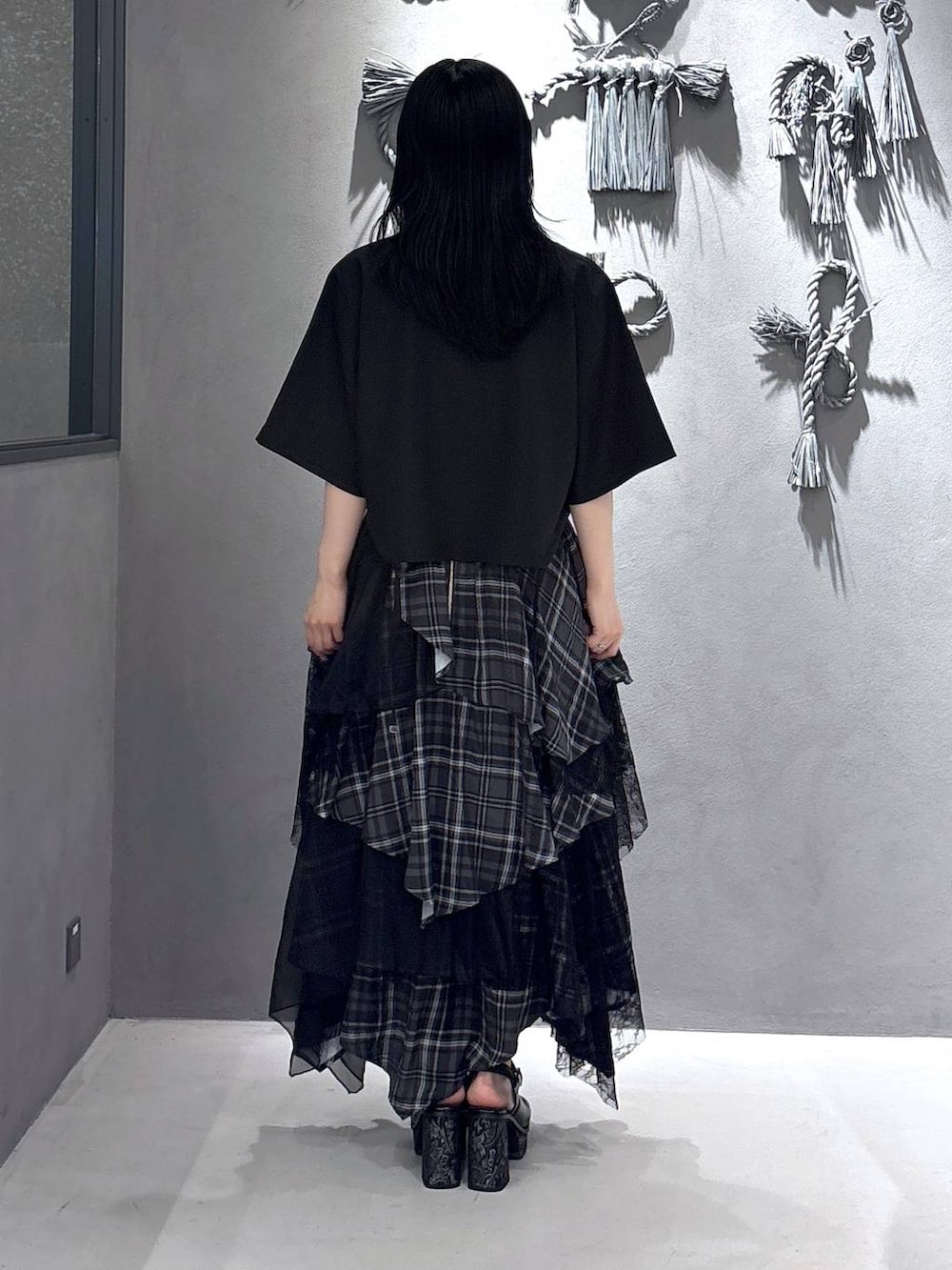 ブラック系のタンクトップ、グレー系のサンダル、ブラック系のスカートを着用したレディースの夏コーディネートの3枚目の写真