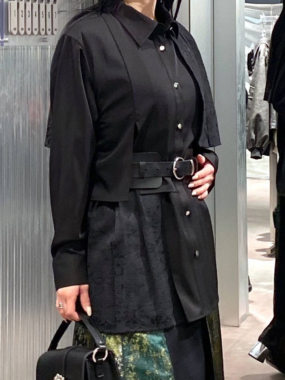 ブラック系のブーツ、イエロー系のスカート、ブラック系のショルダーバッグを着用したレディースの冬コーディネートの6枚目の写真