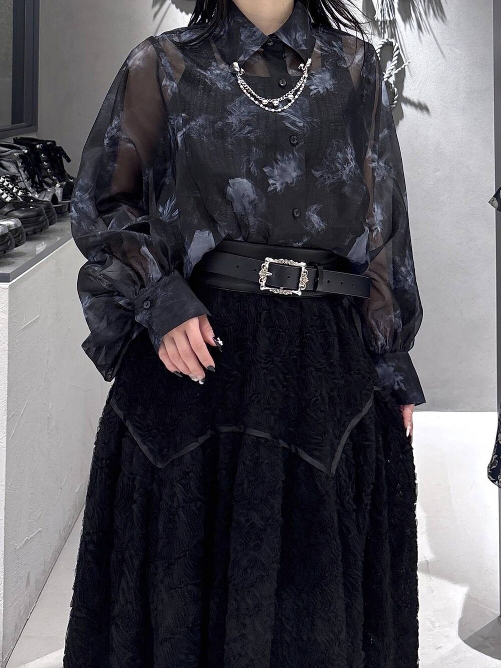 ブラック系のパンプス、ブラック系のタンクトップ、ブラック系のスカートを着用したレディースの春コーディネートの7枚目の写真