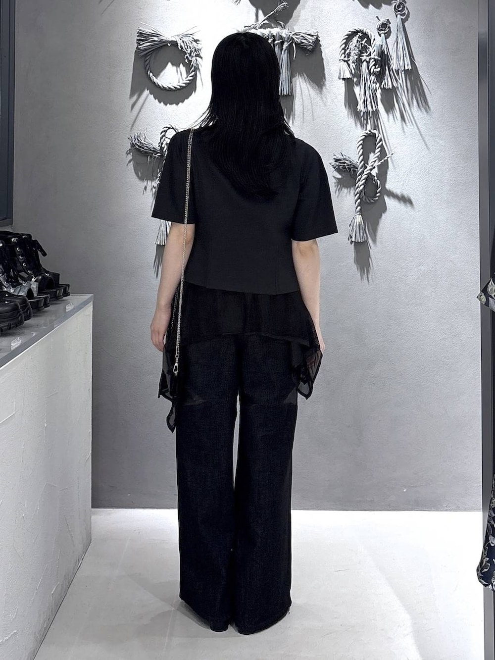 ブラック系のタンクトップ、ブラック系のサンダル、ブラック系のデニムパンツを着用したレディースの春コーディネートの3枚目の写真