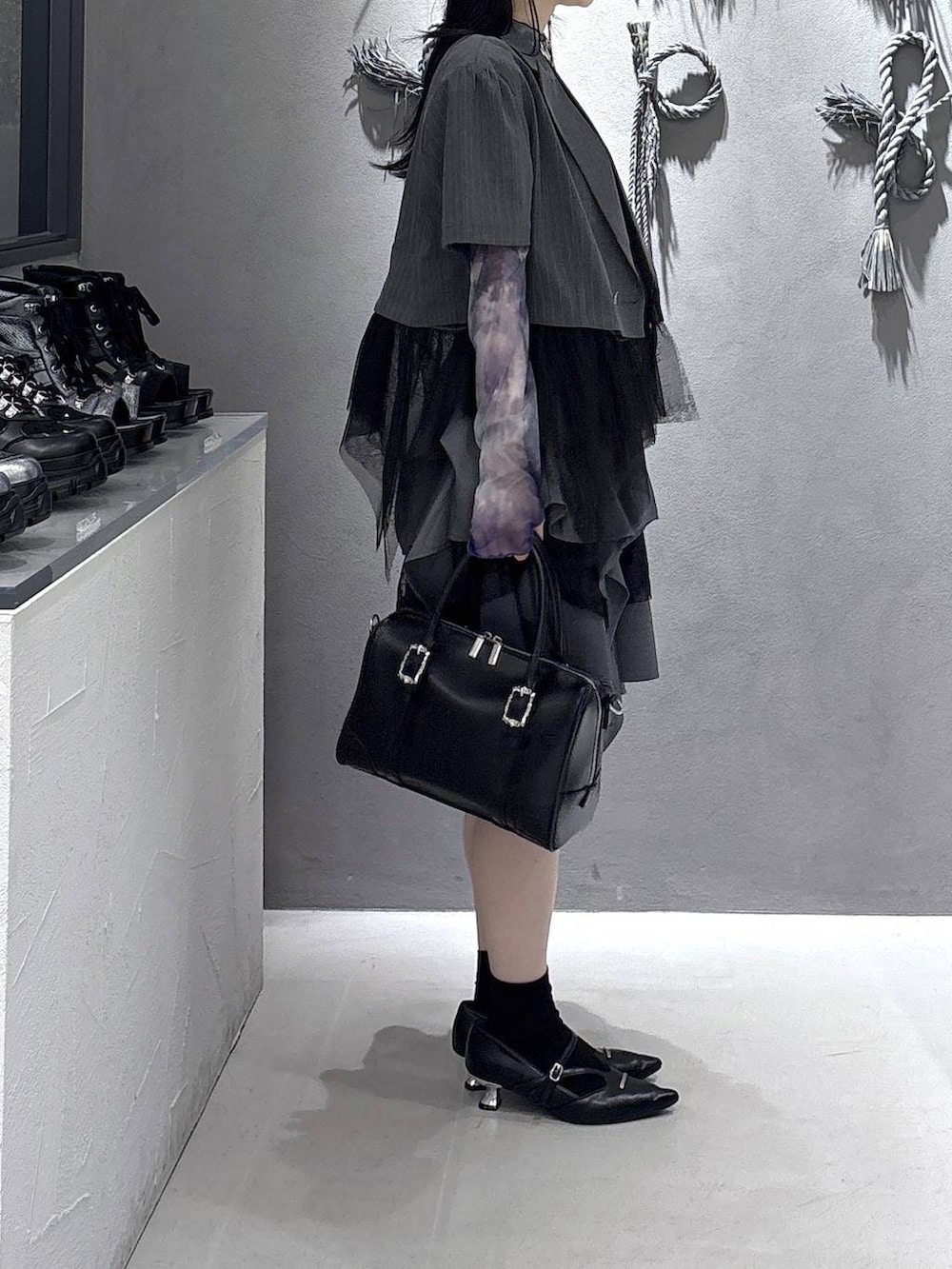 ブラック系のボストンバッグ、ブラック系のパンプス、ブラック系のタンクトップを着用したレディースの春コーディネートの4枚目の写真