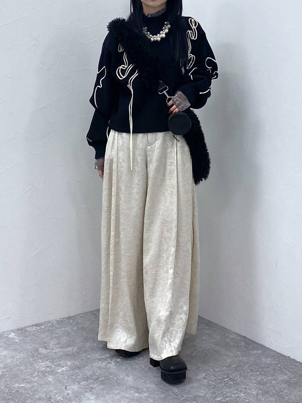 ブラック系のブーツ、ブラック系のショルダーバッグ、ブラック系のニット/セーターを着用したレディースの冬コーディネートの5枚目の写真