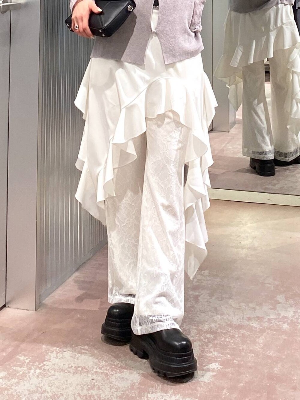 ブラック系のブーツ、ブラック系のショルダーバッグ、ホワイト系のその他パンツを着用したレディースの冬コーディネートの6枚目の写真