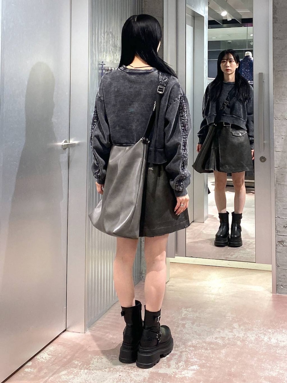 ブラック系のブーツ、グレー系のショルダーバッグ、ブラック系のスウェットを着用したレディースの冬コーディネートの3枚目の写真