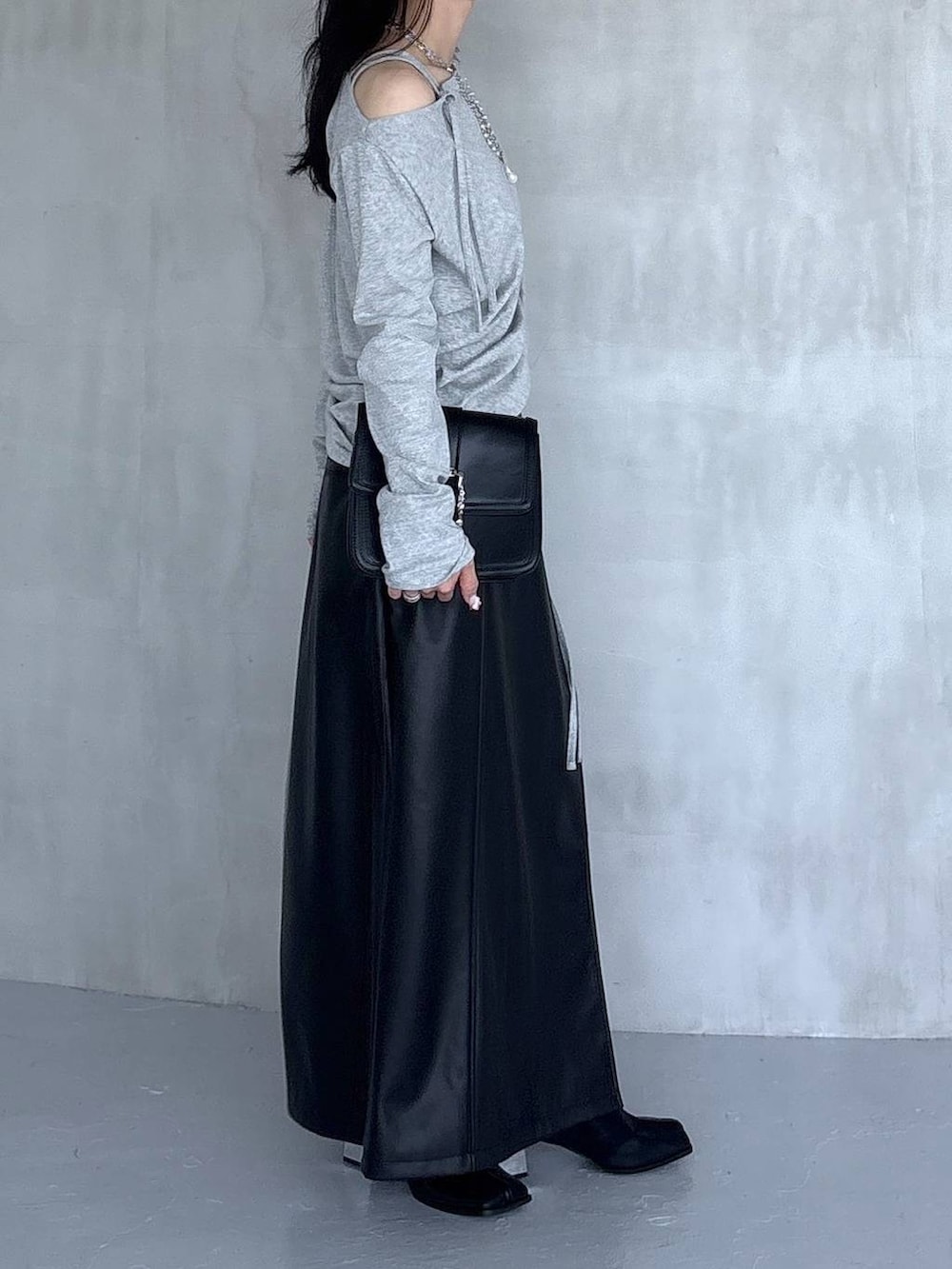 ブラック系のスカート、ブラック系のショルダーバッグ、グレー系のTシャツ/カットソーを着用したレディースの夏コーディネートの4枚目の写真