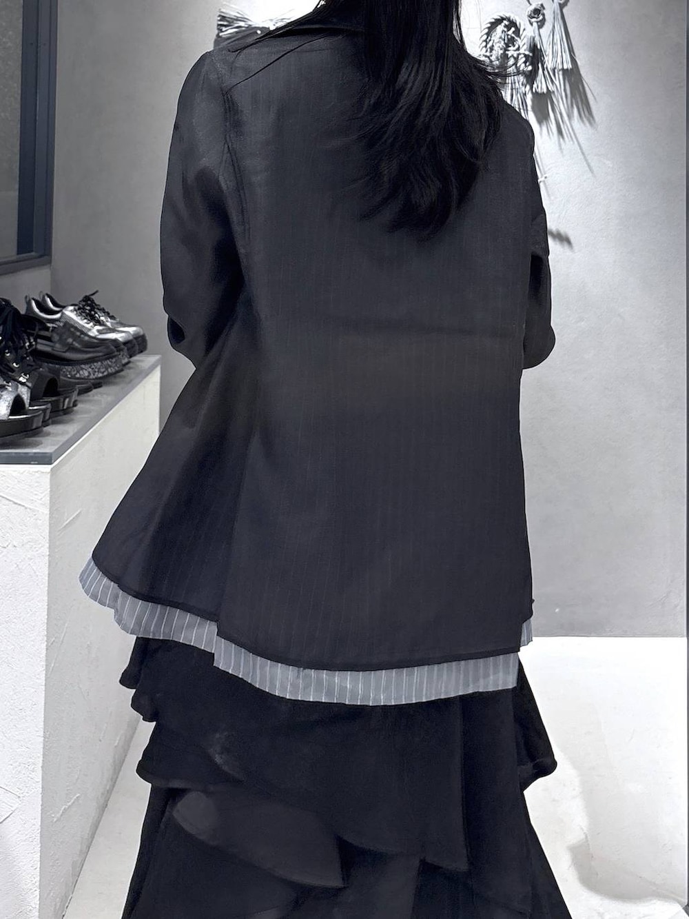 ブラック系のネクタイ、ブラック系のブーツ、パープル系のタンクトップを着用したレディースの春コーディネートの7枚目の写真