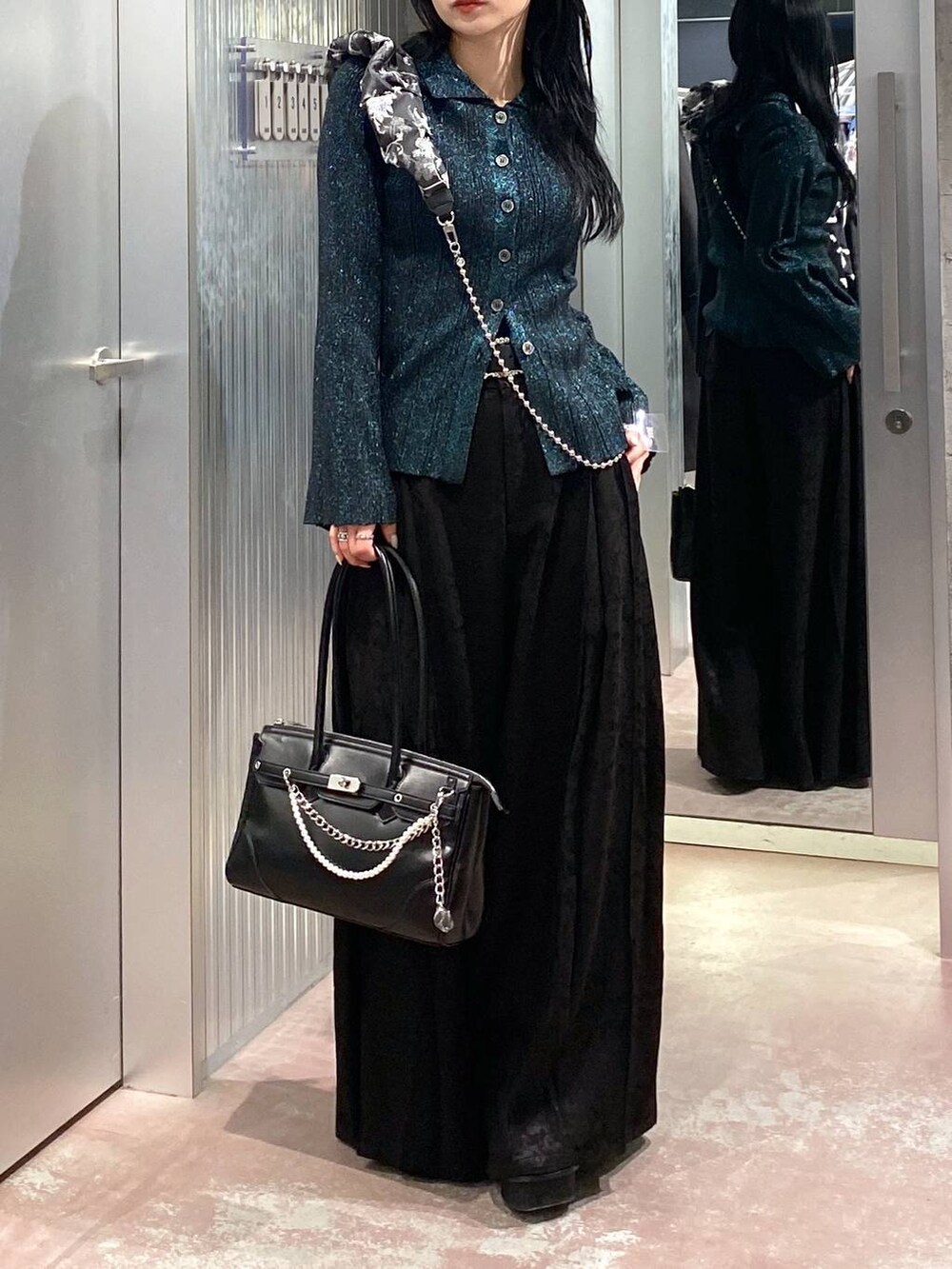 ブラック系のブーツ、ブラック系のボストンバッグ、グリーン系のカーディガン/ボレロを着用したレディースの冬コーディネートの8枚目の写真