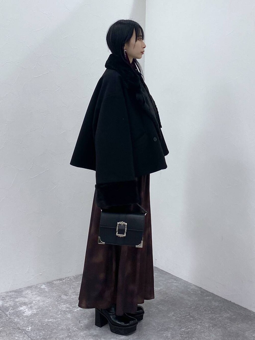 ブラック系のブーツ、ブラック系のショルダーバッグ、ブラック系のその他アウターを着用したレディースの冬コーディネートの4枚目の写真