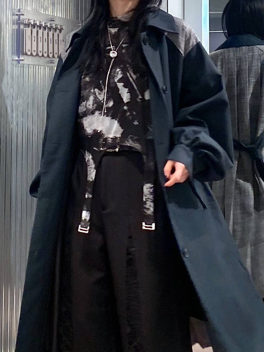 ブラック系のブーツ、グリーン系のステンカラーコート、ブラック系のTシャツ/カットソーを着用したレディースの秋コーディネートの7枚目の写真