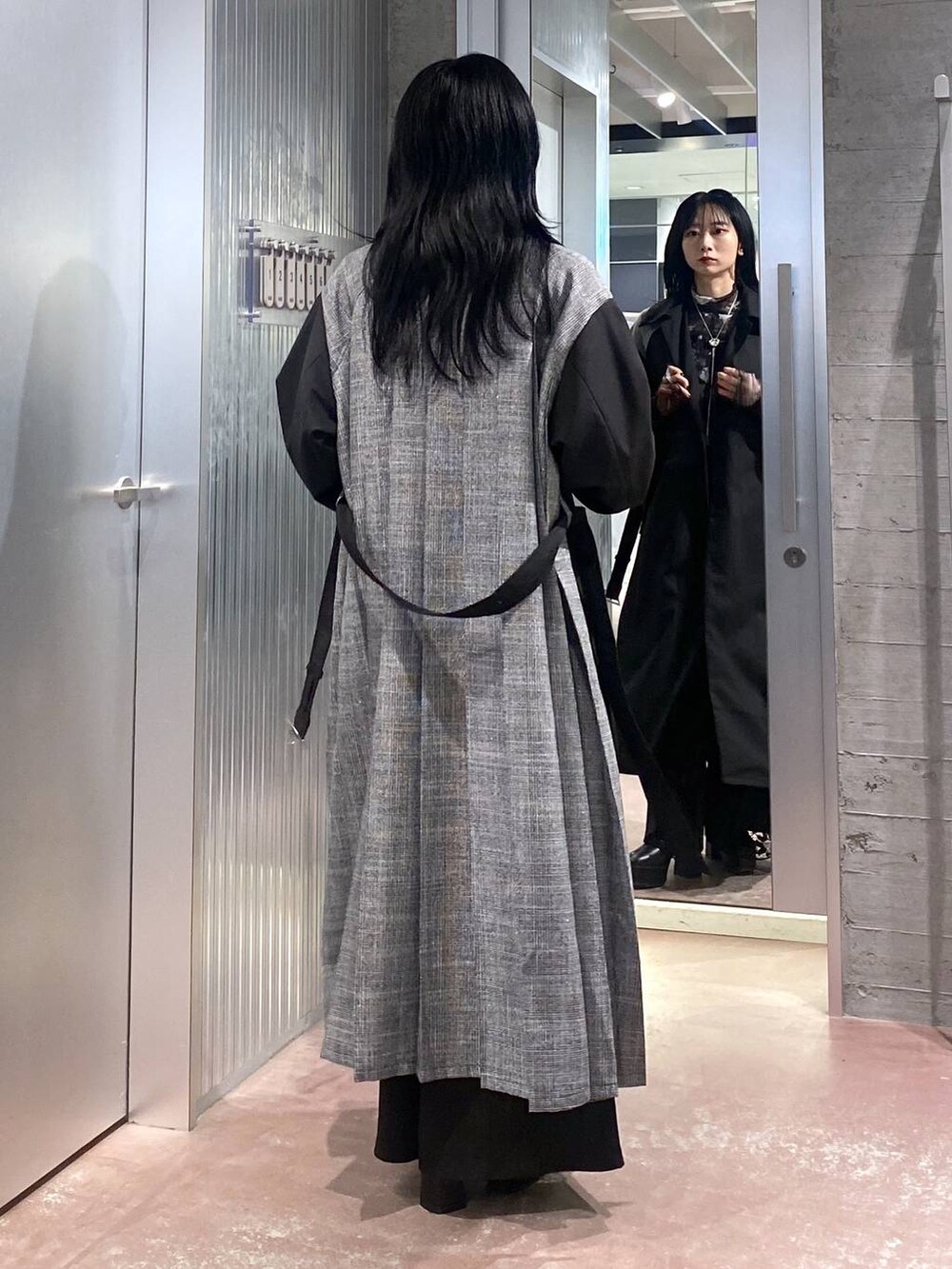 ブラック系のブーツ、ブラック系のステンカラーコート、ブラック系のTシャツ/カットソーを着用したレディースの秋コーディネートの4枚目の写真