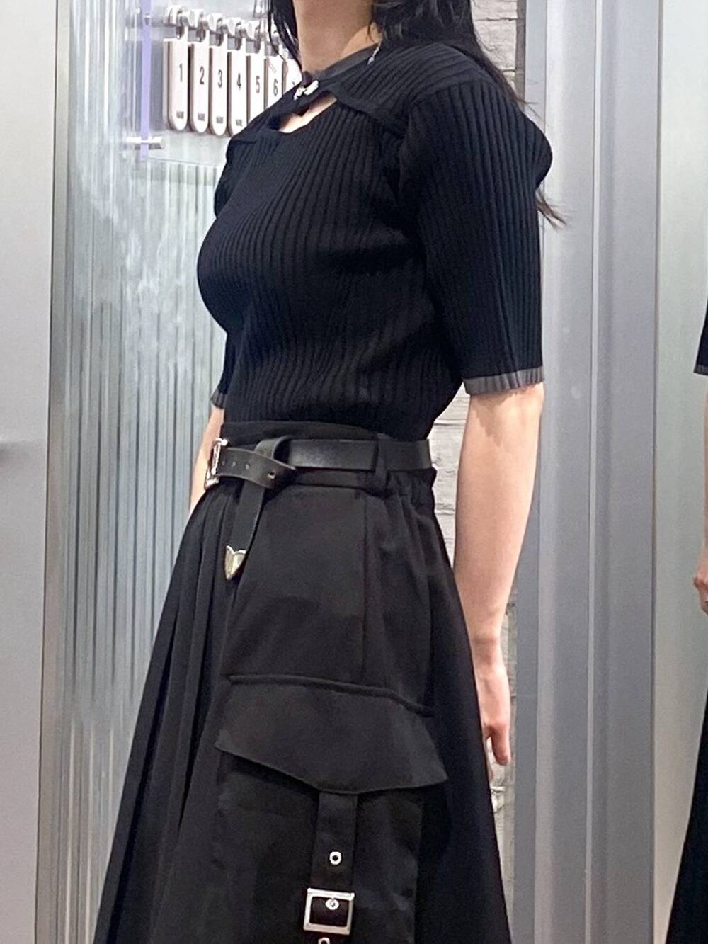 ブラック系のニット/セーター、ブラック系のパンプス、ブラック系のスカートを着用したレディースの夏コーディネートの6枚目の写真