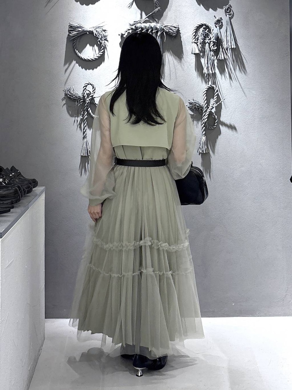 ブラック系のパンプス、ブラック系のショルダーバッグ、イエロー系のワンピースを着用したレディースの春コーディネートの2枚目の写真