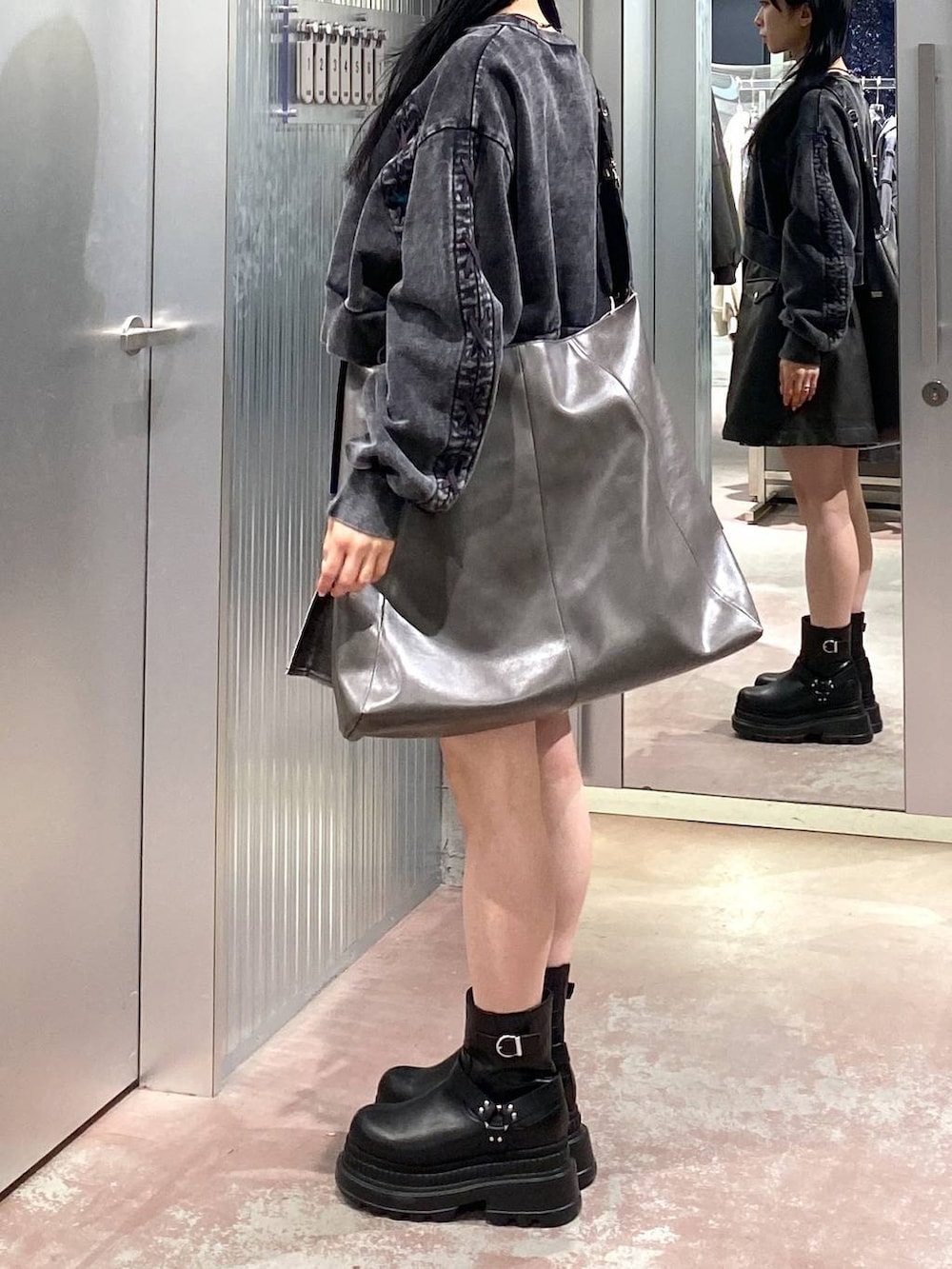 ブラック系のブーツ、グレー系のショルダーバッグ、ブラック系のスウェットを着用したレディースの冬コーディネートの2枚目の写真