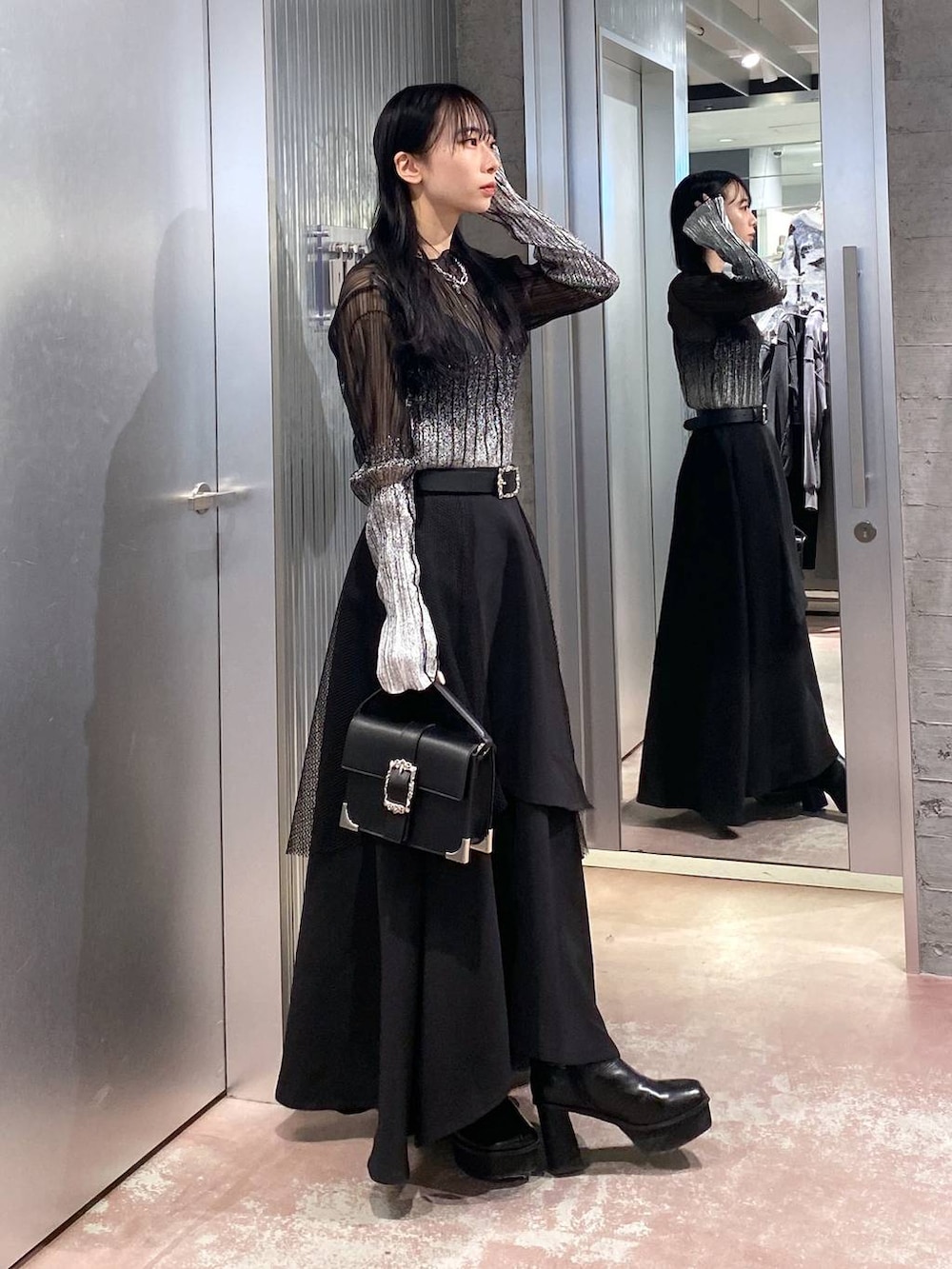 ブラック系のブーツ、ブラック系のショルダーバッグ、ブラック系のTシャツ/カットソーを着用したレディースの冬コーディネートの4枚目の写真