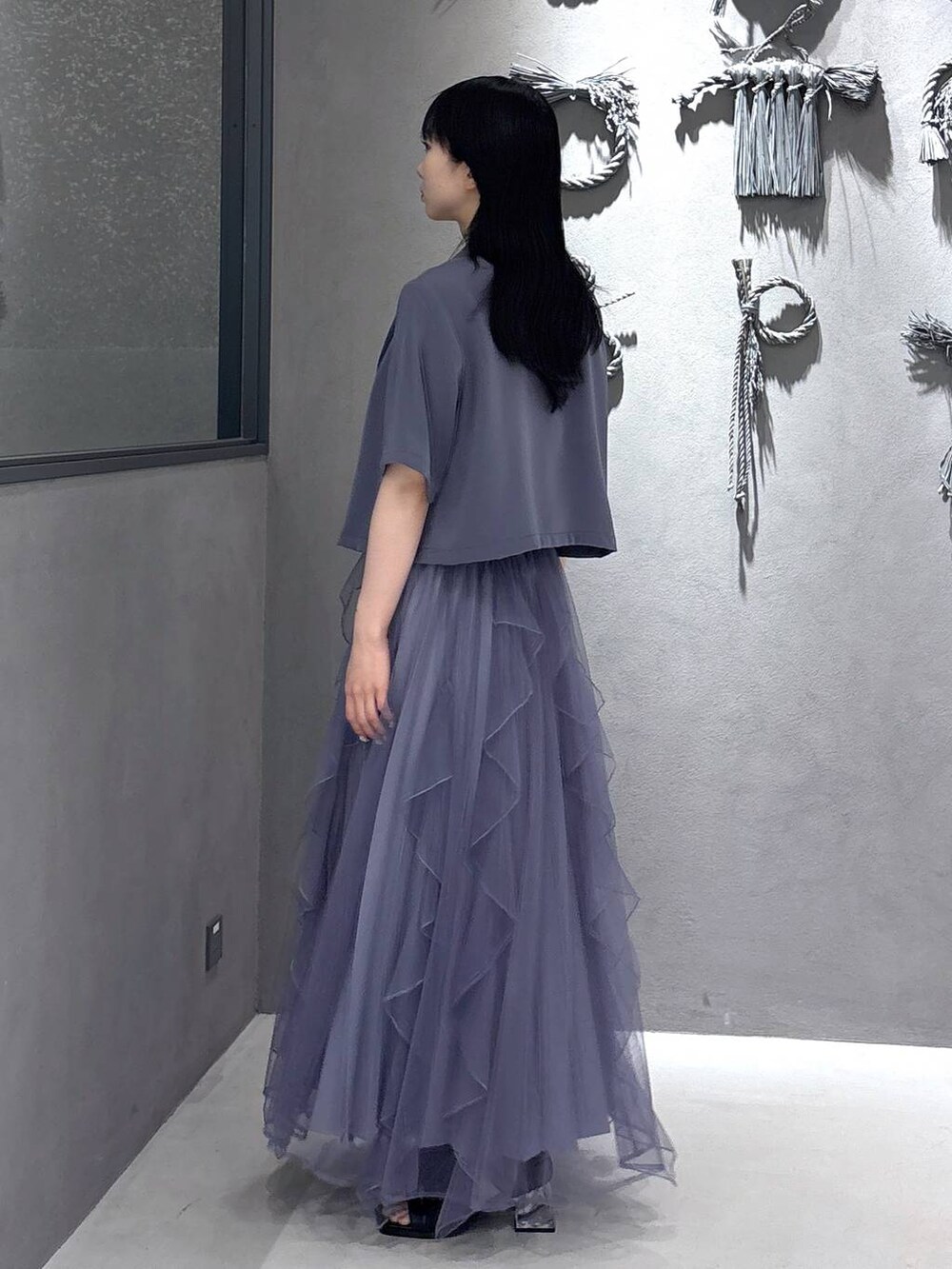 ブラック系のタンクトップ、パープル系のスカート、ブラック系のサンダルを着用したレディースの春コーディネートの2枚目の写真