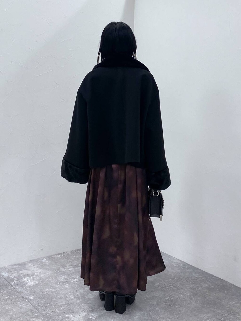 ブラック系のブーツ、ブラック系のショルダーバッグ、ブラック系のその他アウターを着用したレディースの冬コーディネートの3枚目の写真