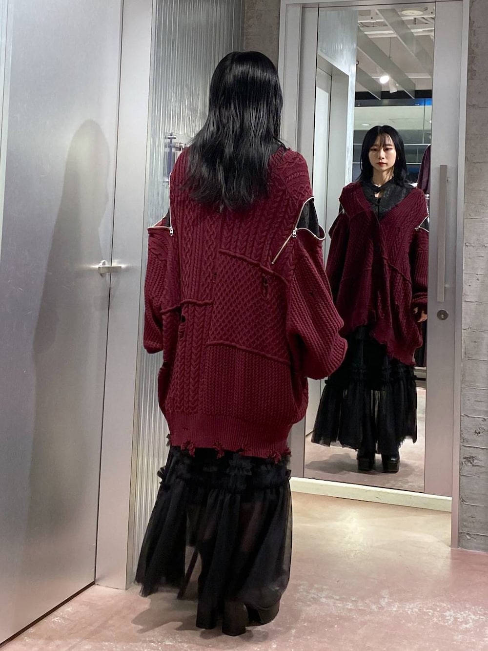 ブラック系のブーツ、レッド系のカーディガン/ボレロ、ブラック系のスカートを着用したレディースの秋コーディネートの3枚目の写真