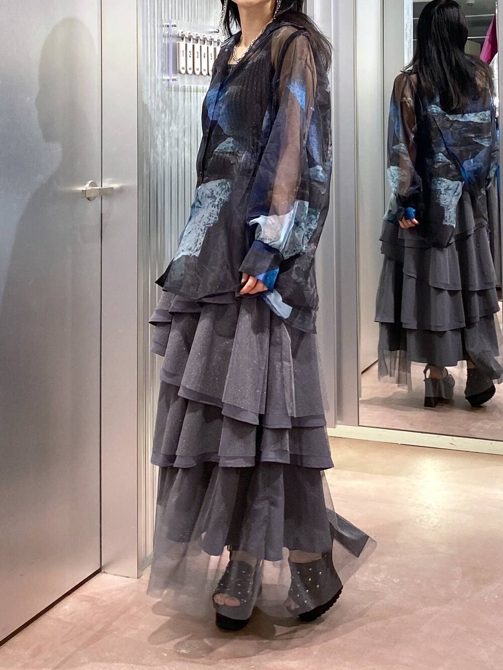 ブラック系のサンダル、ブラック系のタンクトップ、グレー系のスカートを着用したレディースの夏コーディネートの5枚目の写真