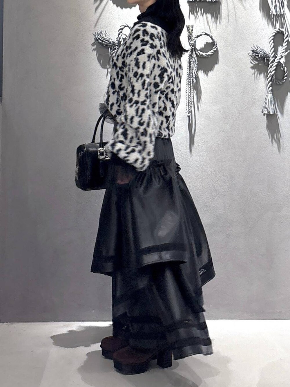 ブラック系のTシャツ/カットソー、ブラック系のボストンバッグ、ブラウン系のブーツを着用したレディースの秋コーディネートの2枚目の写真