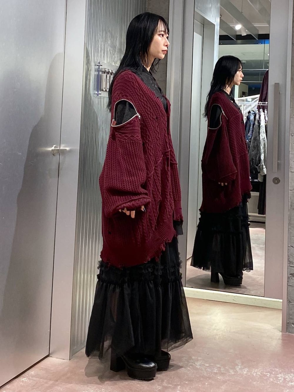ブラック系のブーツ、レッド系のカーディガン/ボレロ、ブラック系のスカートを着用したレディースの秋コーディネートの4枚目の写真