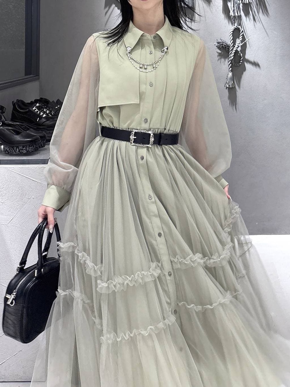 ブラック系のパンプス、ブラック系のショルダーバッグ、イエロー系のワンピースを着用したレディースの春コーディネートの6枚目の写真