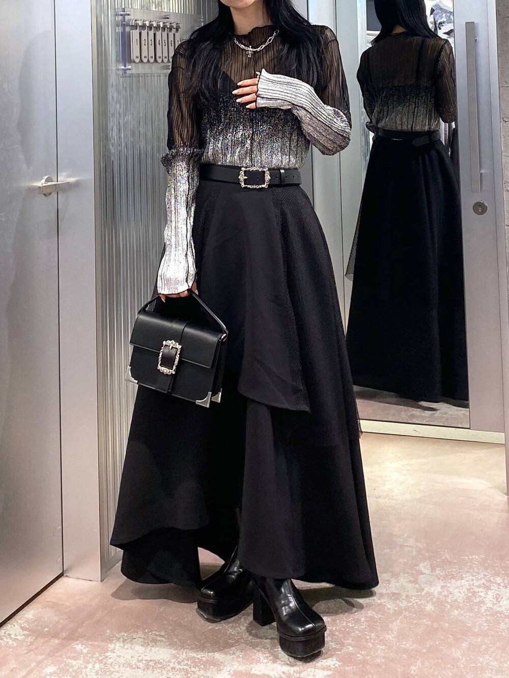 ブラック系のブーツ、ブラック系のショルダーバッグ、ブラック系のTシャツ/カットソーを着用したレディースの冬コーディネートの5枚目の写真