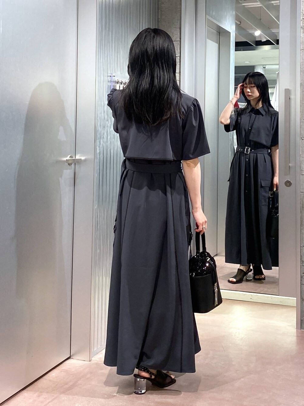 ブラック系のサンダル、グレー系のワンピース、ブラック系のショルダーバッグを着用したレディースの夏コーディネートの3枚目の写真