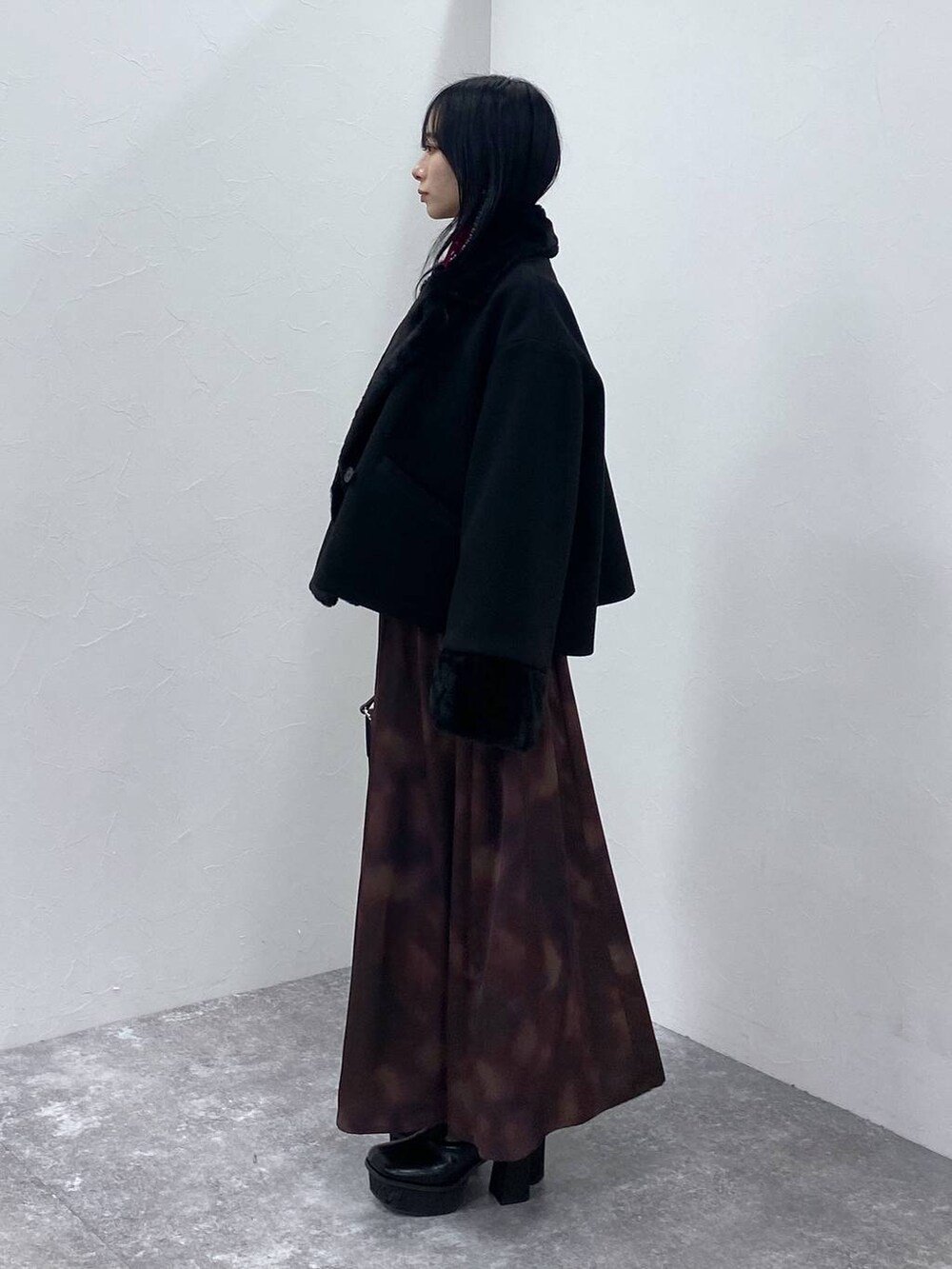 ブラック系のブーツ、ブラック系のショルダーバッグ、ブラック系のその他アウターを着用したレディースの冬コーディネートの2枚目の写真