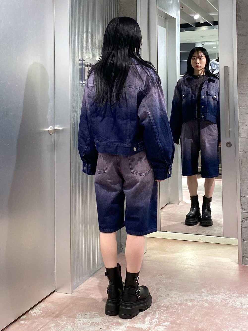 グレー系のニット/セーター、ブラック系のブーツ、パープル系のデニムジャケットを着用したレディースの冬コーディネートの5枚目の写真