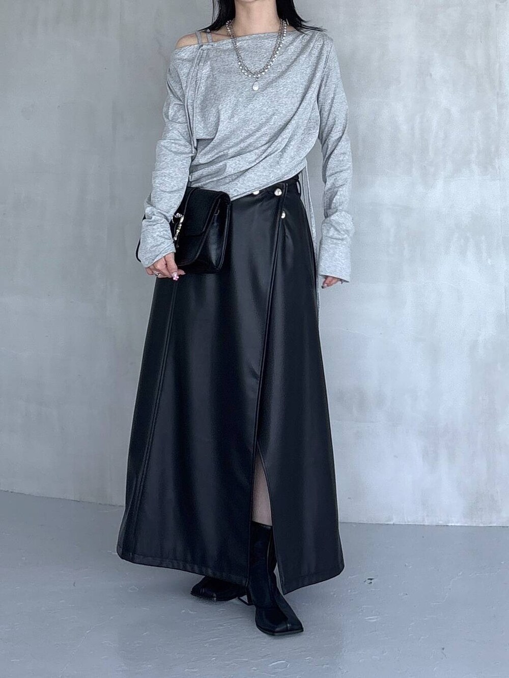 ブラック系のスカート、ブラック系のショルダーバッグ、グレー系のTシャツ/カットソーを着用したレディースの夏コーディネートの5枚目の写真