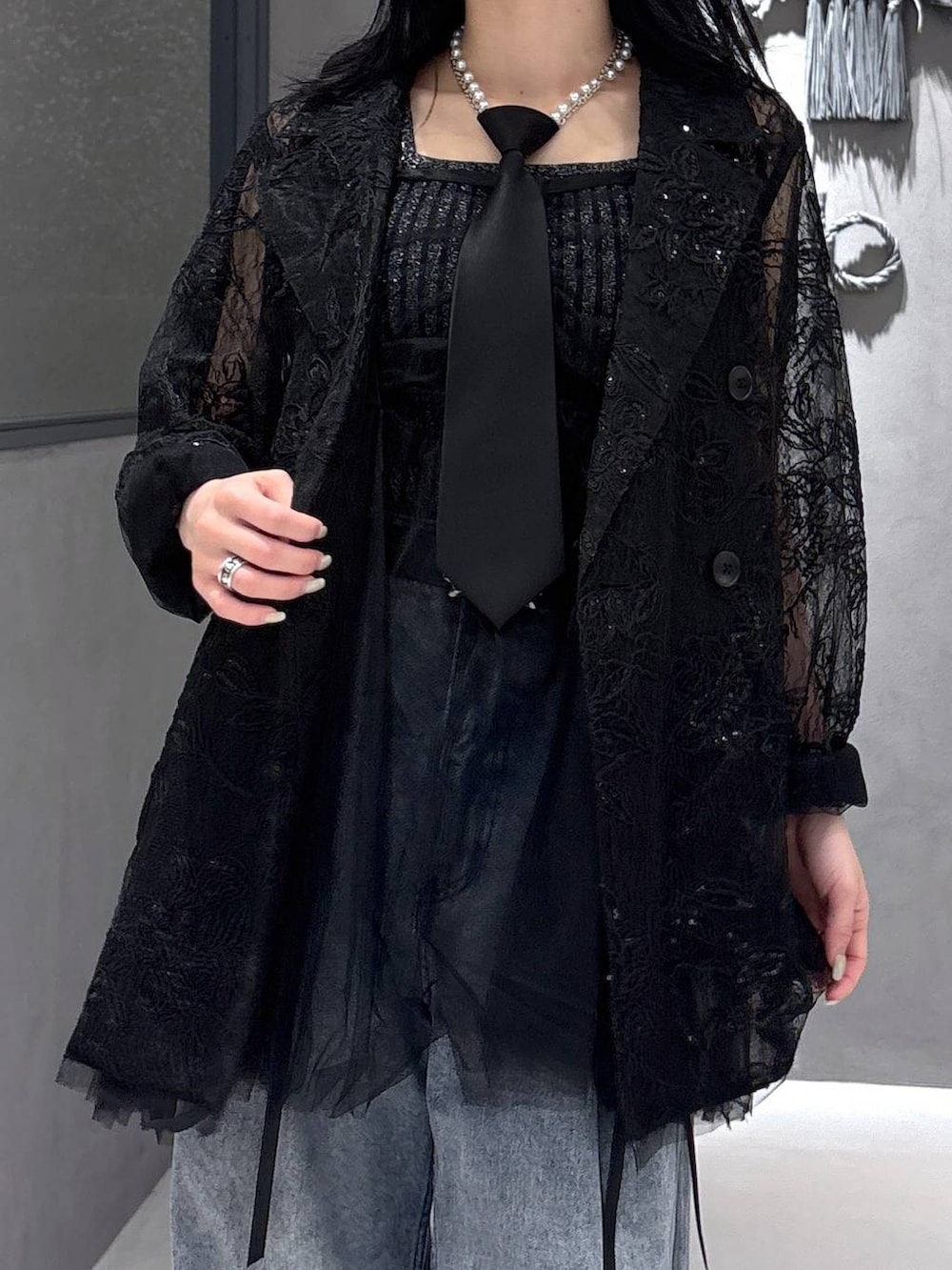 ブラック系のネクタイ、ブラック系のタンクトップ、ブラック系のテーラードジャケットを着用したレディースの春コーディネートの6枚目の写真