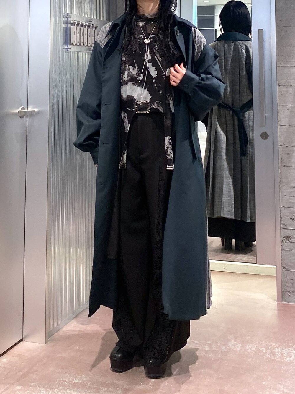 ブラック系のブーツ、グリーン系のステンカラーコート、ブラック系のTシャツ/カットソーを着用したレディースの秋コーディネートの9枚目の写真