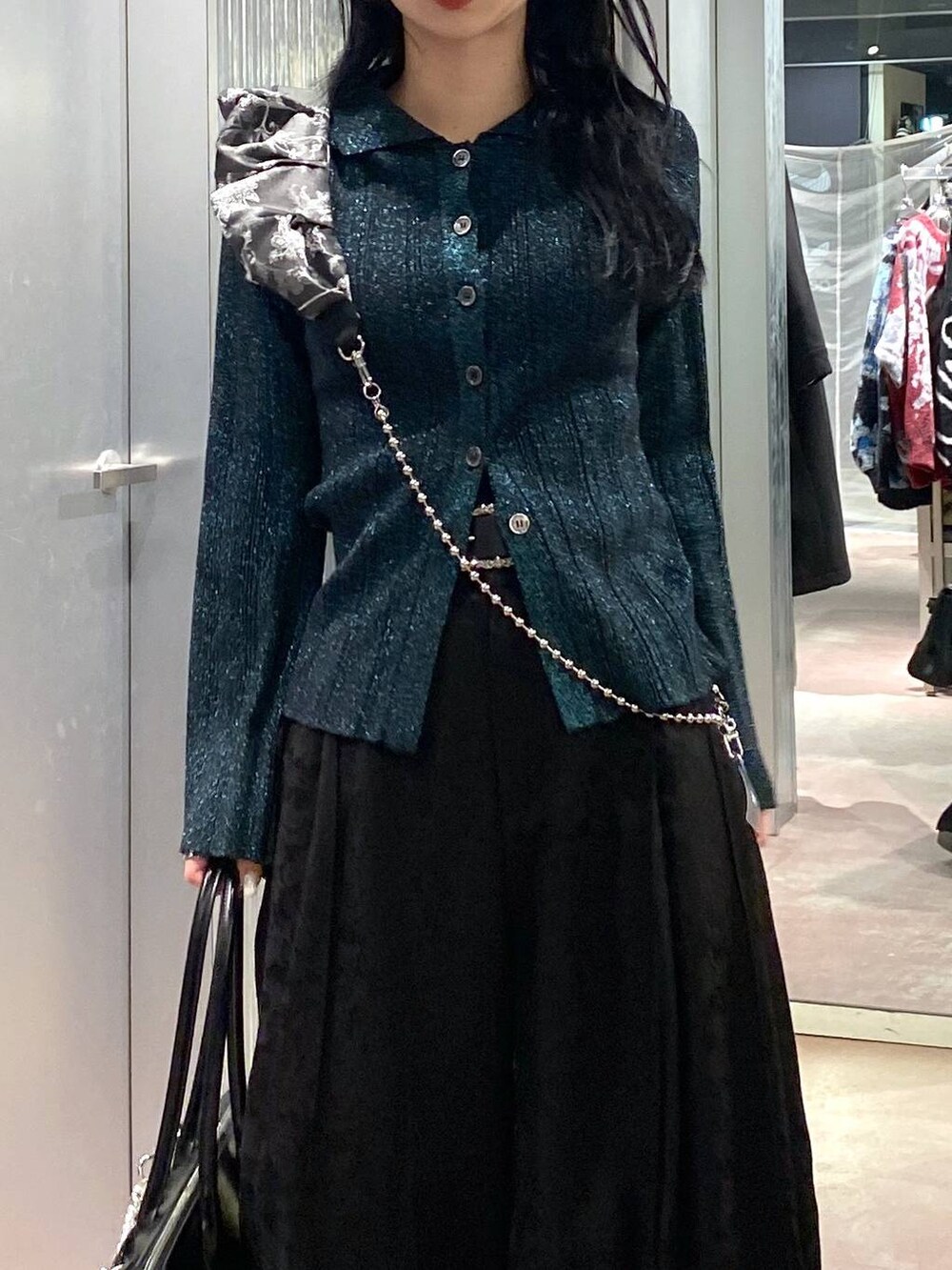 ブラック系のブーツ、ブラック系のボストンバッグ、グリーン系のカーディガン/ボレロを着用したレディースの冬コーディネートの7枚目の写真