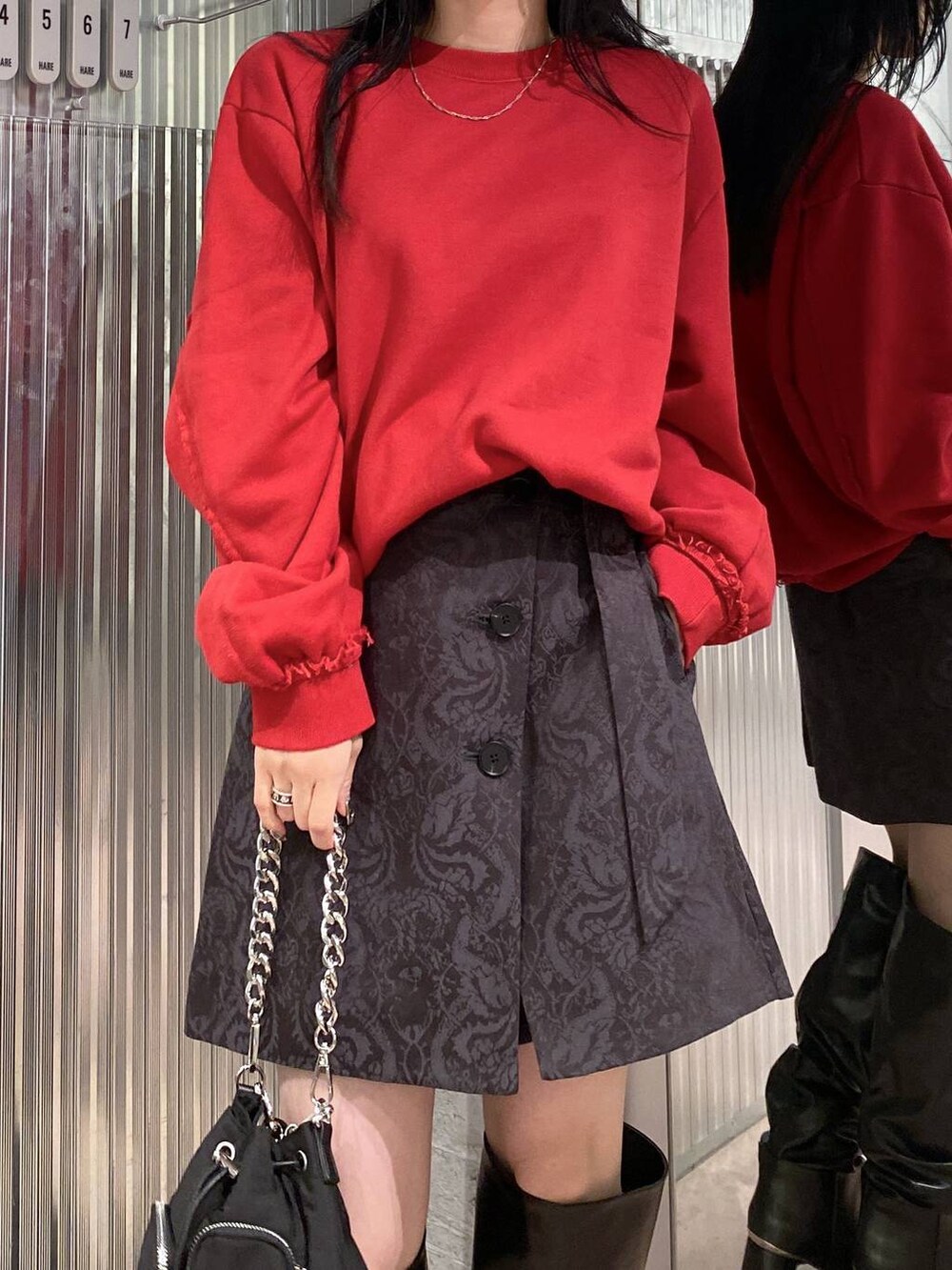 ブラック系のショルダーバッグ、レッド系のスウェット、グレー系のその他パンツを着用したレディースの夏コーディネートの9枚目の写真
