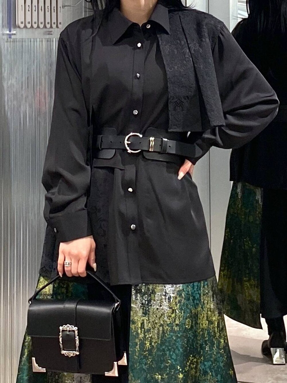 ブラック系のブーツ、イエロー系のスカート、ブラック系のショルダーバッグを着用したレディースの冬コーディネートの9枚目の写真