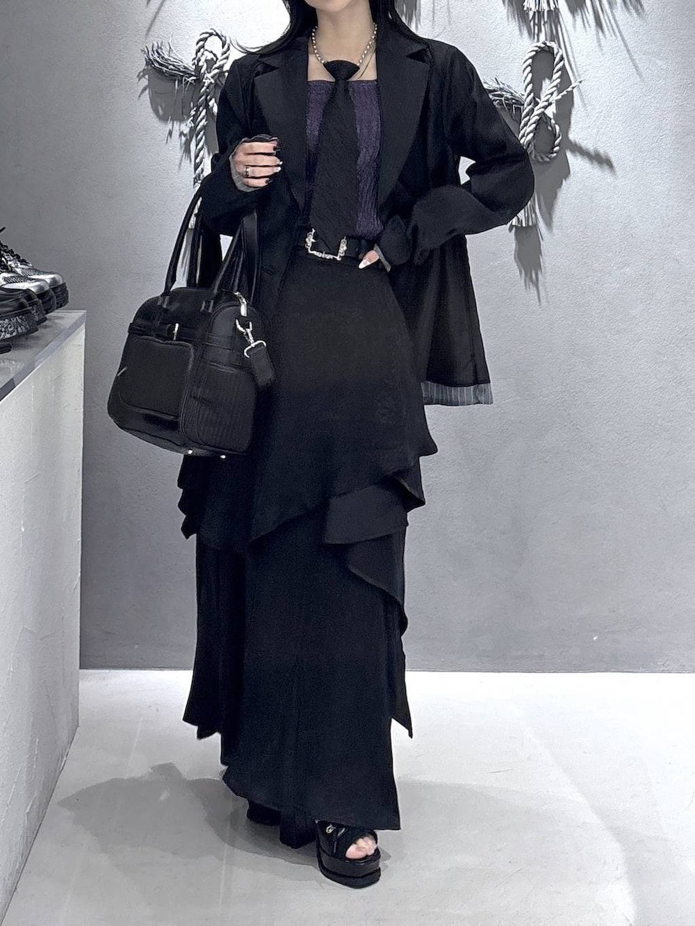 ブラック系のネクタイ、ブラック系のブーツ、パープル系のタンクトップを着用したレディースの春コーディネートの5枚目の写真