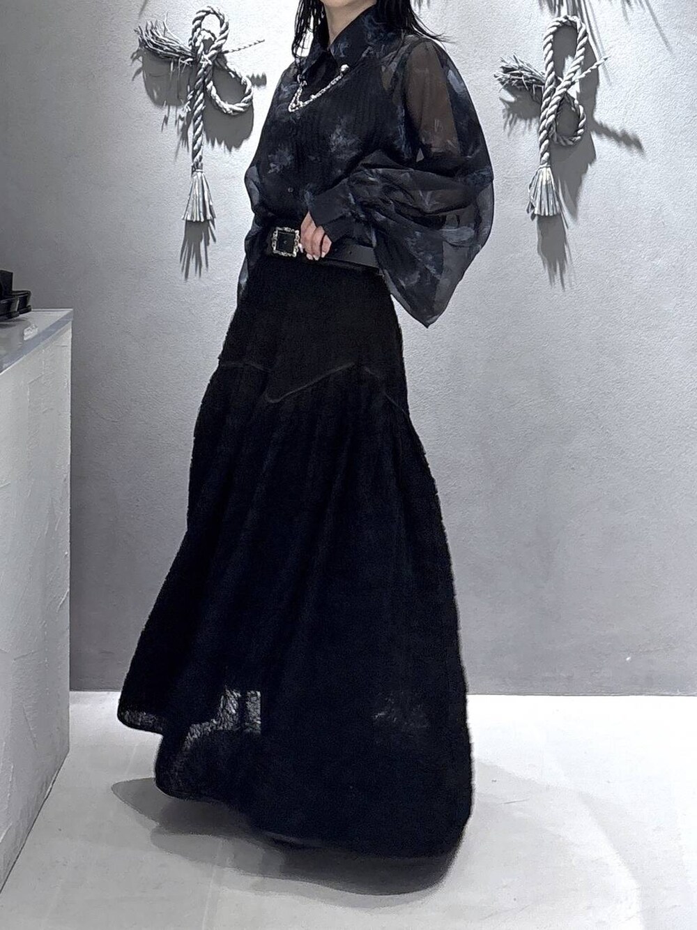 ブラック系のパンプス、ブラック系のタンクトップ、ブラック系のスカートを着用したレディースの春コーディネートの9枚目の写真