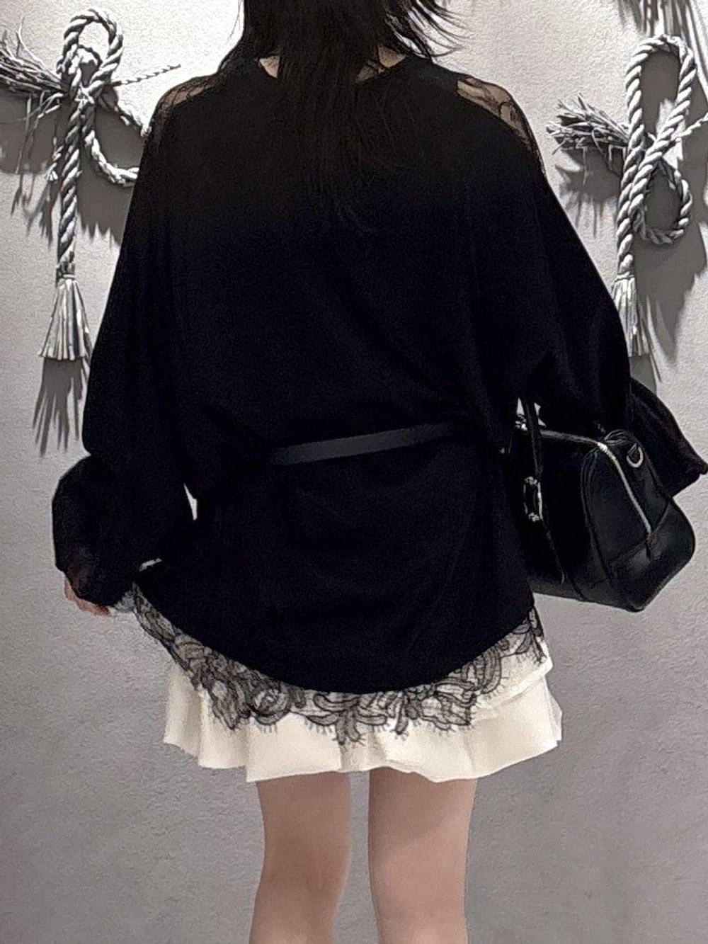 ブラック系のボストンバッグ、ブラック系のパンプス、ホワイト系のスカートを着用したレディースの冬コーディネートの9枚目の写真