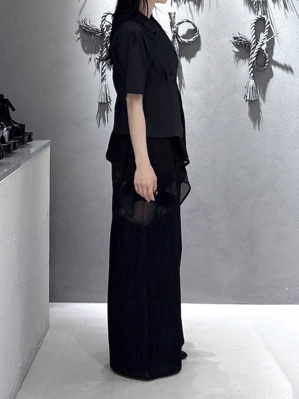 ブラック系のタンクトップ、ブラック系のサンダル、ブラック系のデニムパンツを着用したレディースの春コーディネートの4枚目の写真