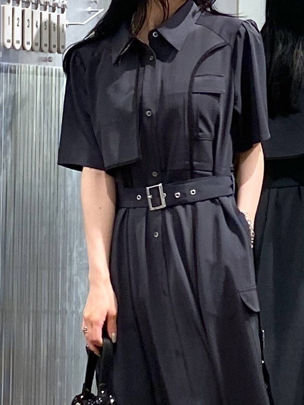 ブラック系のサンダル、グレー系のワンピース、ブラック系のショルダーバッグを着用したレディースの夏コーディネートの5枚目の写真