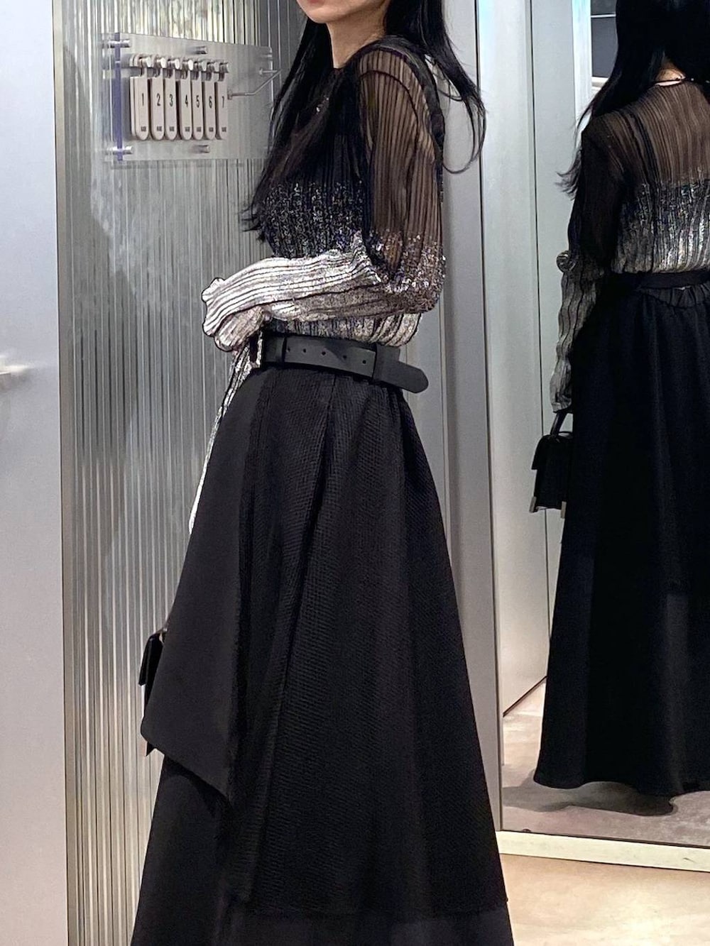 ブラック系のブーツ、ブラック系のショルダーバッグ、ブラック系のTシャツ/カットソーを着用したレディースの冬コーディネートの6枚目の写真
