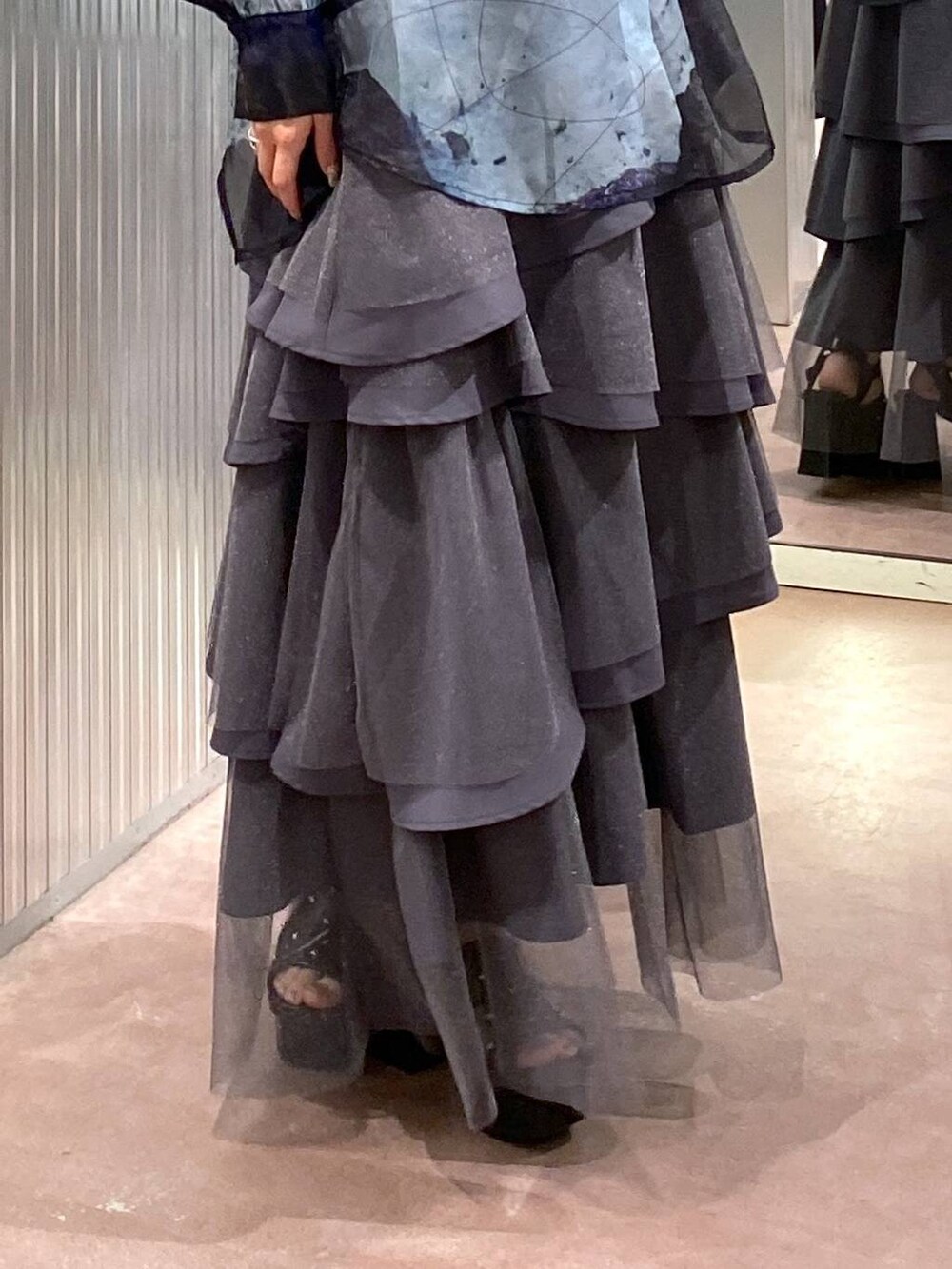 ブラック系のサンダル、ブラック系のタンクトップ、グレー系のスカートを着用したレディースの夏コーディネートの7枚目の写真