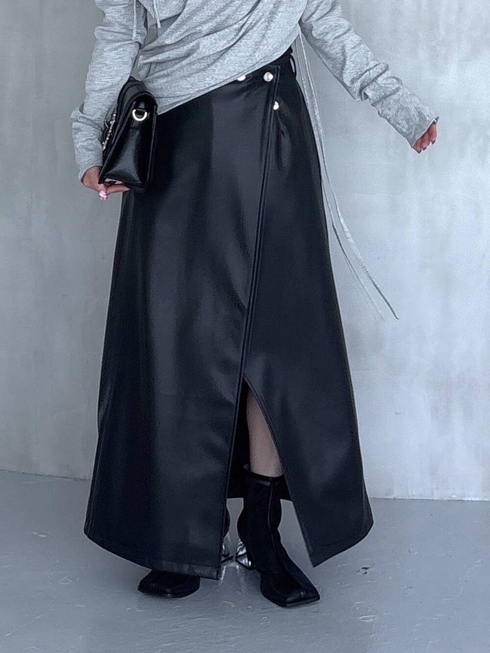 ブラック系のスカート、ブラック系のショルダーバッグ、グレー系のTシャツ/カットソーを着用したレディースの夏コーディネートの8枚目の写真