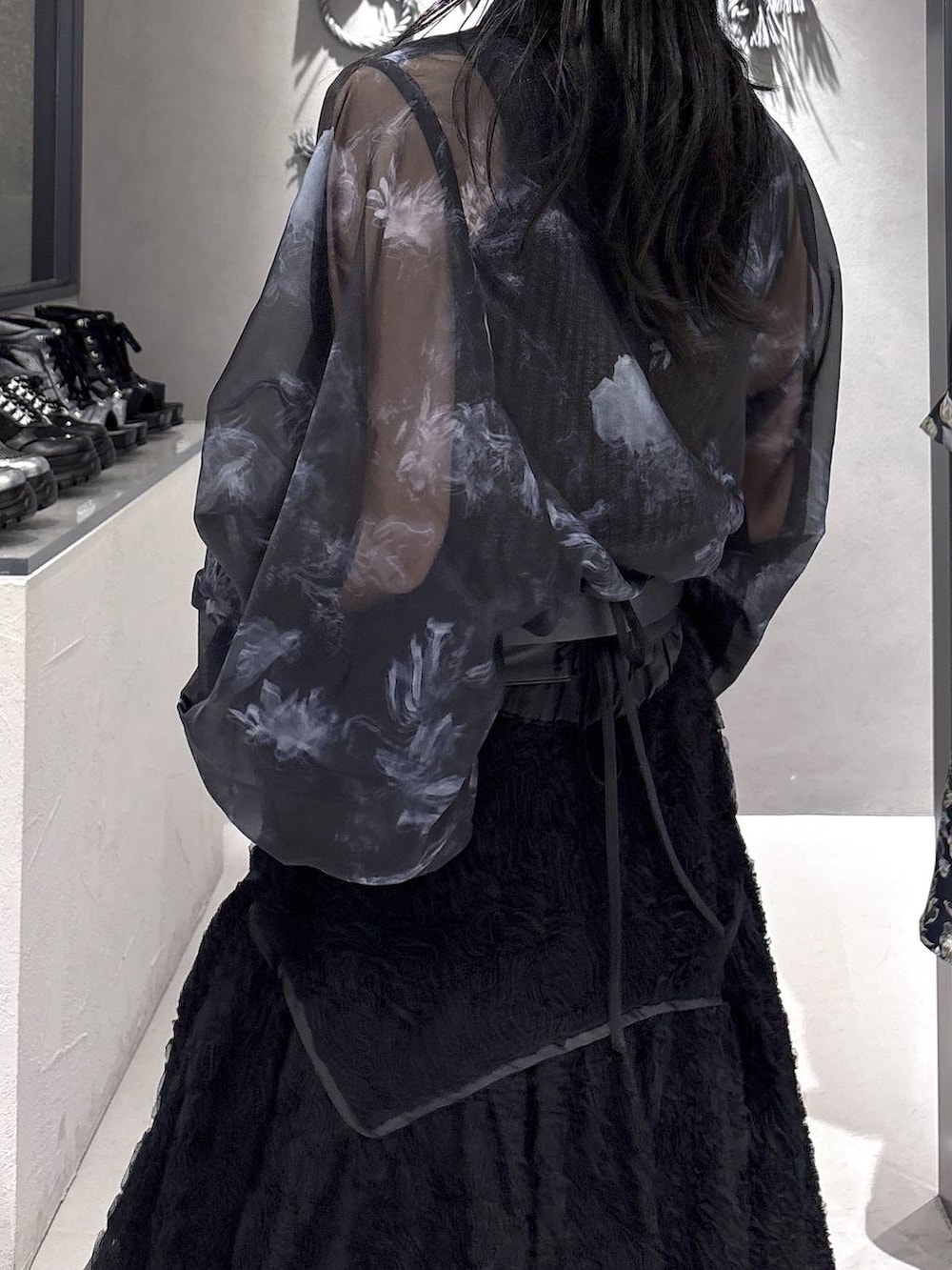 ブラック系のパンプス、ブラック系のタンクトップ、ブラック系のスカートを着用したレディースの春コーディネートの6枚目の写真