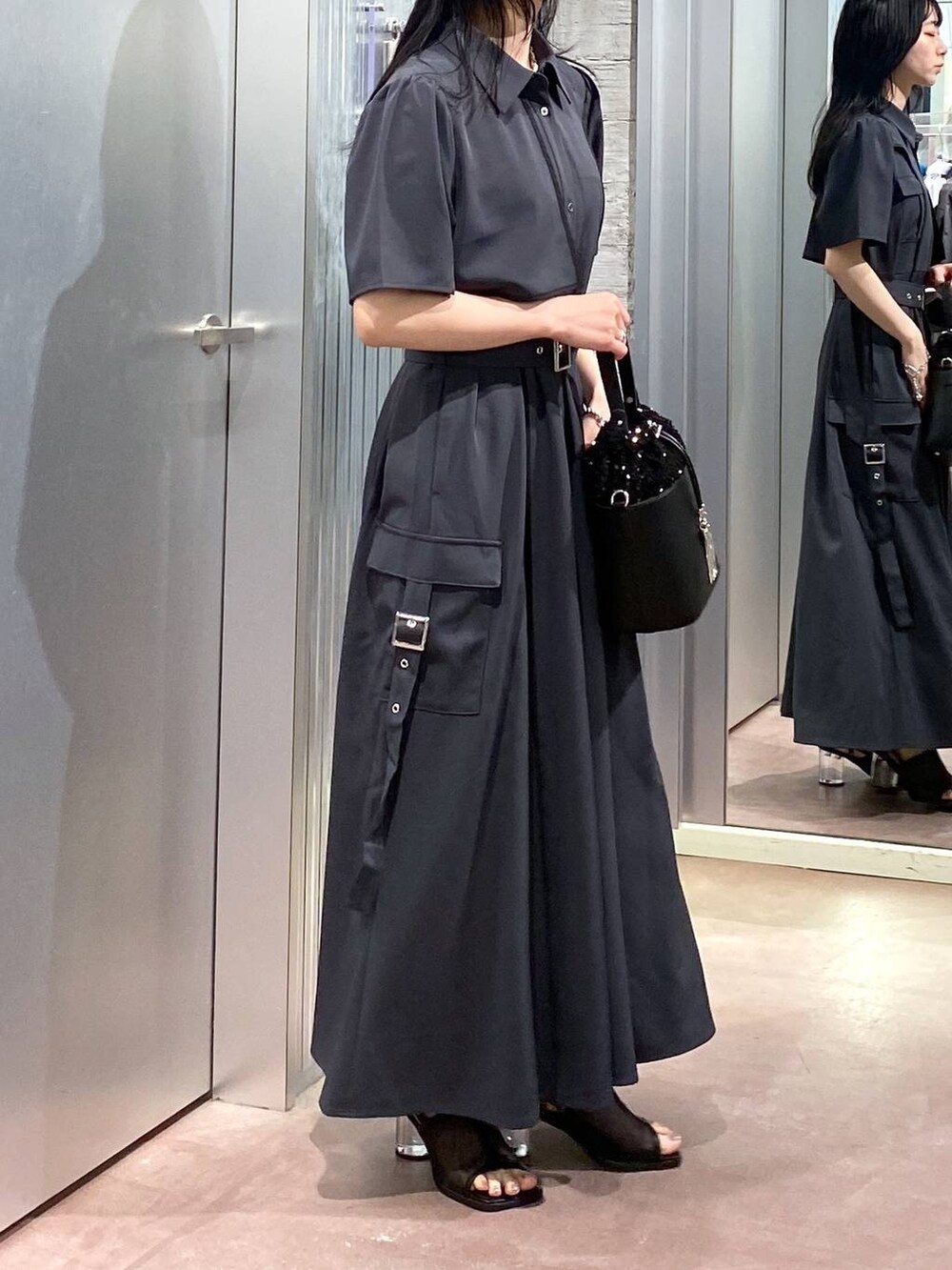 ブラック系のサンダル、グレー系のワンピース、ブラック系のショルダーバッグを着用したレディースの夏コーディネートの4枚目の写真