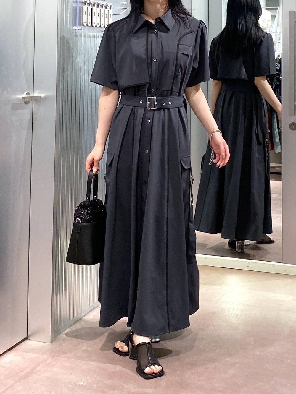 ブラック系のサンダル、グレー系のワンピース、ブラック系のショルダーバッグを着用したレディースの夏コーディネートの6枚目の写真