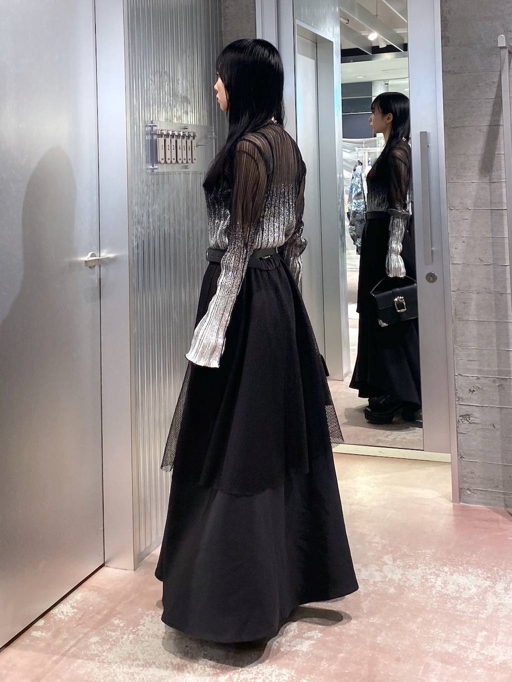 ブラック系のブーツ、ブラック系のショルダーバッグ、ブラック系のTシャツ/カットソーを着用したレディースの冬コーディネートの2枚目の写真
