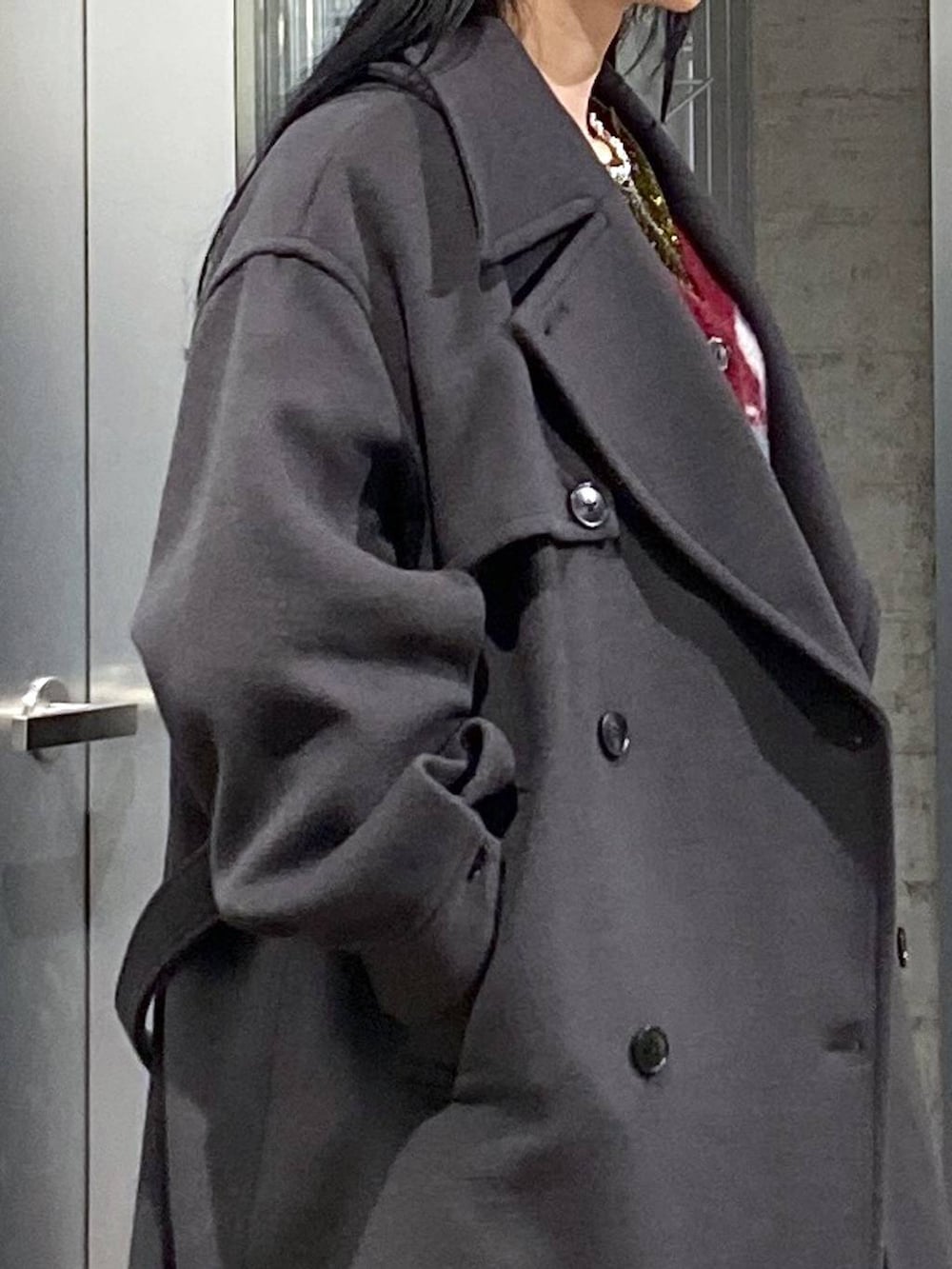 グレー系のトレンチコート、レッド系のカーディガン/ボレロ、イエロー系のTシャツ/カットソーを着用したレディースの冬コーディネートの8枚目の写真